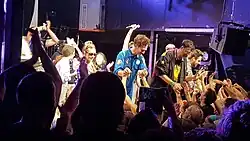 Picture of the band Siamés, surrounded by concert-goers.