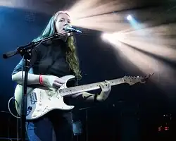 Sidney Gish onstage with a guitar and microphone