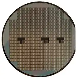 A silicon wafer; individual devices (VLSI in squares) are not usable until diced, wire-bonded, and packaged