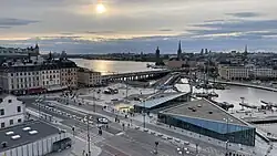 The Slussen area photographed from Katarinahissen in June 2025. Landmarks from left to right: Västerbron, Södermalmstorg, Stockholm City Hall, Riddarholmen Church, Klara Church, Vattentorget.