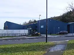 Blue building partially obscured by sheeting.