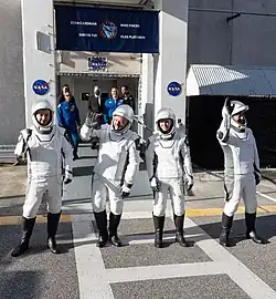 Crew-11 astronauts walk out from the O&C Building