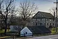 View from the north showing Mill, spring house and carriage house (2024)