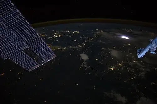 A sprite seen from the International Space Station (top right, faint red above the lightning)