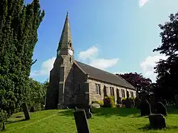 Black and white photograph of the church of St John, the steeple prominent against the sky