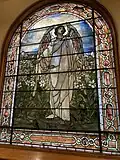 Stained glass window of angel on east side of sanctuary with folded glass
