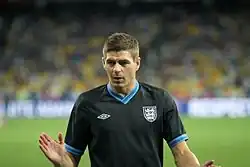 Gerrard warming up in a black England shirt
