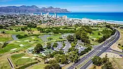 An aerial view of Strand with the Coast Road and Strand Golf Club in the foreground