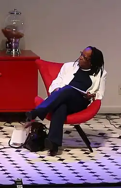 Suely Carneiro, sitting on a red armchair, at the Festival Latinidades, 2016
