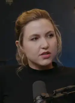 Tomlinson speaking into a microphone