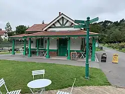 The pavilion; a green and white coloured building, with a brick-red tiled roof