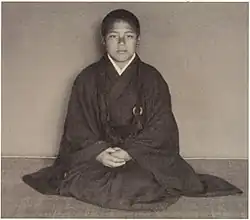 Portrait of a boy priest, seated and facing the camera