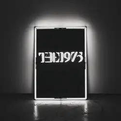 A black-and-white photo showcasing a rectangular, glowing neon sign against a wall in the near-center saying "The 1975".