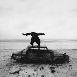 Lead singer Matthew Healy posing on a car graffitied with chalk