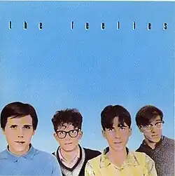 Pastel pictures of The Feelies' faces on a blue background with "THE FEELIES" written in black above them