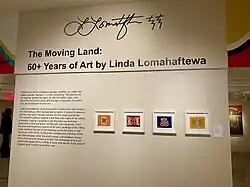 Entrance to the exhibition, showing the title, curatorial statement, and four 2D artworks.