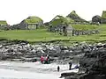The sandy beach of Koltur and the old houses Heimi í Garði