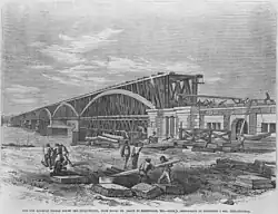 A drawing of a multi-span wooden truss bridge under construction