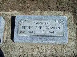 A color photograph of the grave marker for Betty Sue Gravlin, who was born in 1961 and died in 1964. The marker identifies her as the daughter of someone not named on the stone.