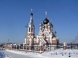 Large Orthodox church in the snow, against a blue sky