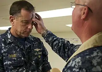 A Naval air officer receives ashes from a military chaplain aboard a U.S. Navy ship, 2011.