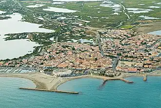 Aerial view of Saintes-Maries-de-la-Mer by the sea with the arena in the foreground