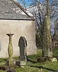 View of sundial and both the standing and fallen cross shafts. The fallen shaft is at the foot of the sundial.