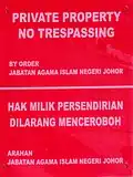 A sign outside the gate of the mosque forbidding people (except for prayer times) from trespassing within the private property