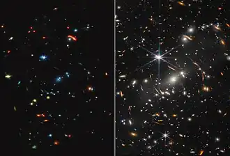 This frame is split down the middle. Webb’s mid-infrared image is shown at left, and Webb’s near-infrared image on the right. The mid-infrared image appears much darker, with many fewer points of light. Stars have very short diffraction spikes. Galaxies and stars also appear in a range of colors, including blue, green, yellow, and red. The near-infrared image appears busier, with many more points of light. Thousands of galaxies and stars appear all across the view. They are sharper and more distinct than what is seen in the mid-infrared view. Some galaxies are shades of orange, while others are white. Most stars appear blue with long diffraction spikes, forming an eight-pointed star shapes. There are also many thin, long, orange arcs that curve around the center of the image.[54]