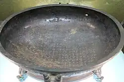 a broad bronze pan, with a lengthy inscription on the flat area inside