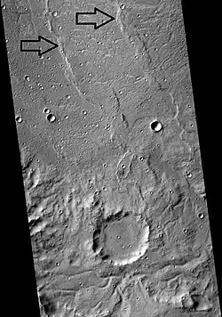 Floor and eroded south wall of the crater Flaugergues on Mars. Arrows point to wrinkle ridges.