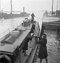 Wrens of the British Fleet Mail load the packet boat to deliver letters and parcels to the men on board ships moored nearby, 1944