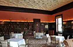 A bookshelf-lined library, with arranged tables and chairs