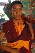 Young Tibetan Drummer with his drum on his shoulder gets prepared to play on Bodhisattva Day!