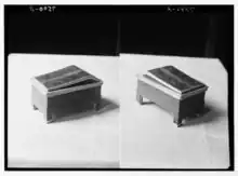 Two, side-by-side monochromatic images of showing three-quarters view of an ornate wooden box inscribed with an Egyptian hieroglyph cartouche.