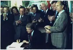 Carter surrounded by a crowd of people as he signs the Airline Deregulation Act.